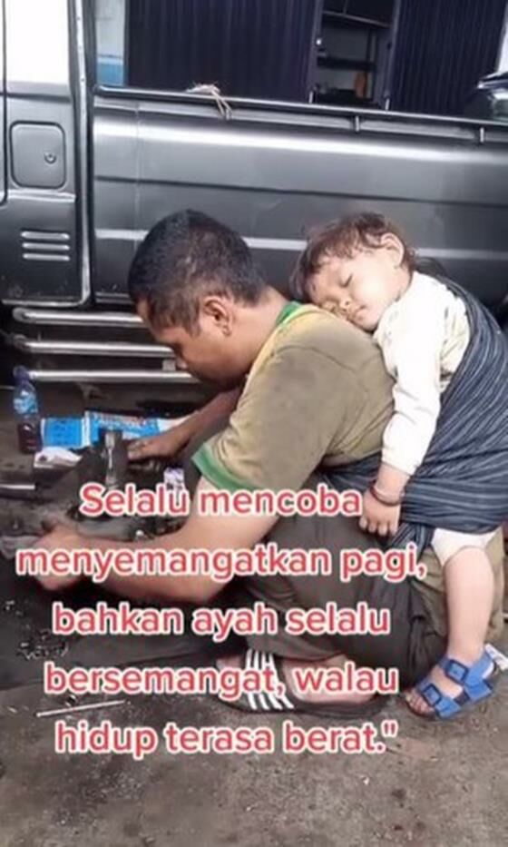 Ayah Kerja Di Bengkel Sambil Gendong Anak Tidur D040a